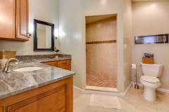 Updated bathroom with granite vanity, new flooring, and tiled walk-in shower