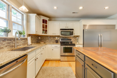 Bright white kitchen remodel with granite counters and tile backsplash