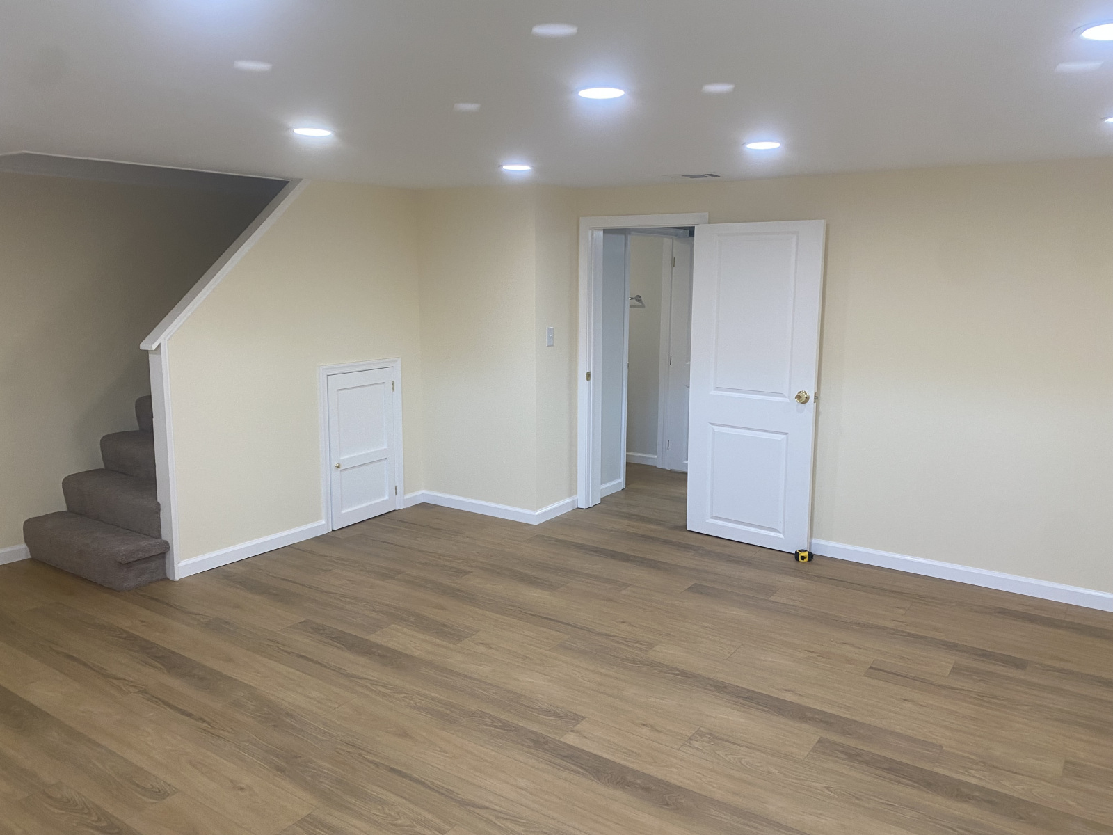 Finished Maryland basement with luxury vinyl plank flooring, recessed lighting, and under-stair storage