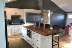 Vaulted-ceiling kitchen with white cabinets and butcher-block island