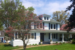 Two-story home exterior with covered front porch and fresh siding