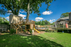 Custom backyard playset with treehouse, slide, and deck