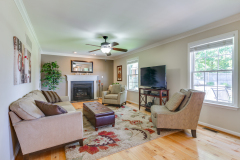 Bright family room with stone fireplace and refinished hardwoods