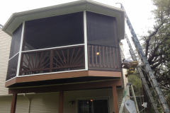 Second-story screened-in porch with bronze railings and shingle roof