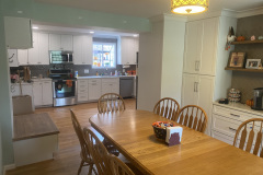 Open kitchen and dining area with white cabinets and butcher-block table