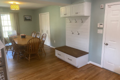 Custom mudroom built-in bench with coat hooks and shaker storage