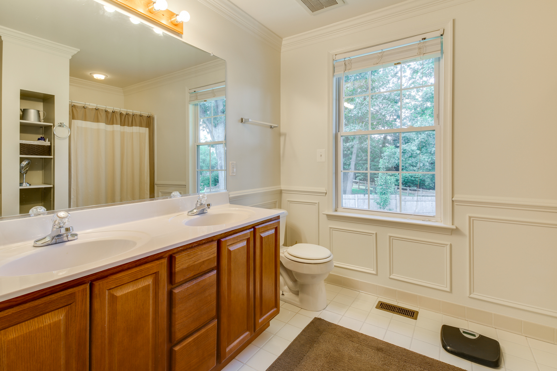 Hall bathroom before remodel with oak vanity and white wainscoting