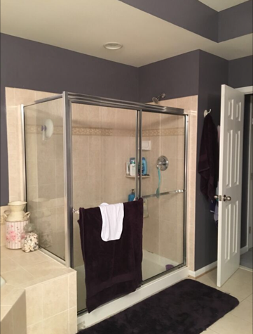 Original framed-glass shower before remodel with tan tile surround