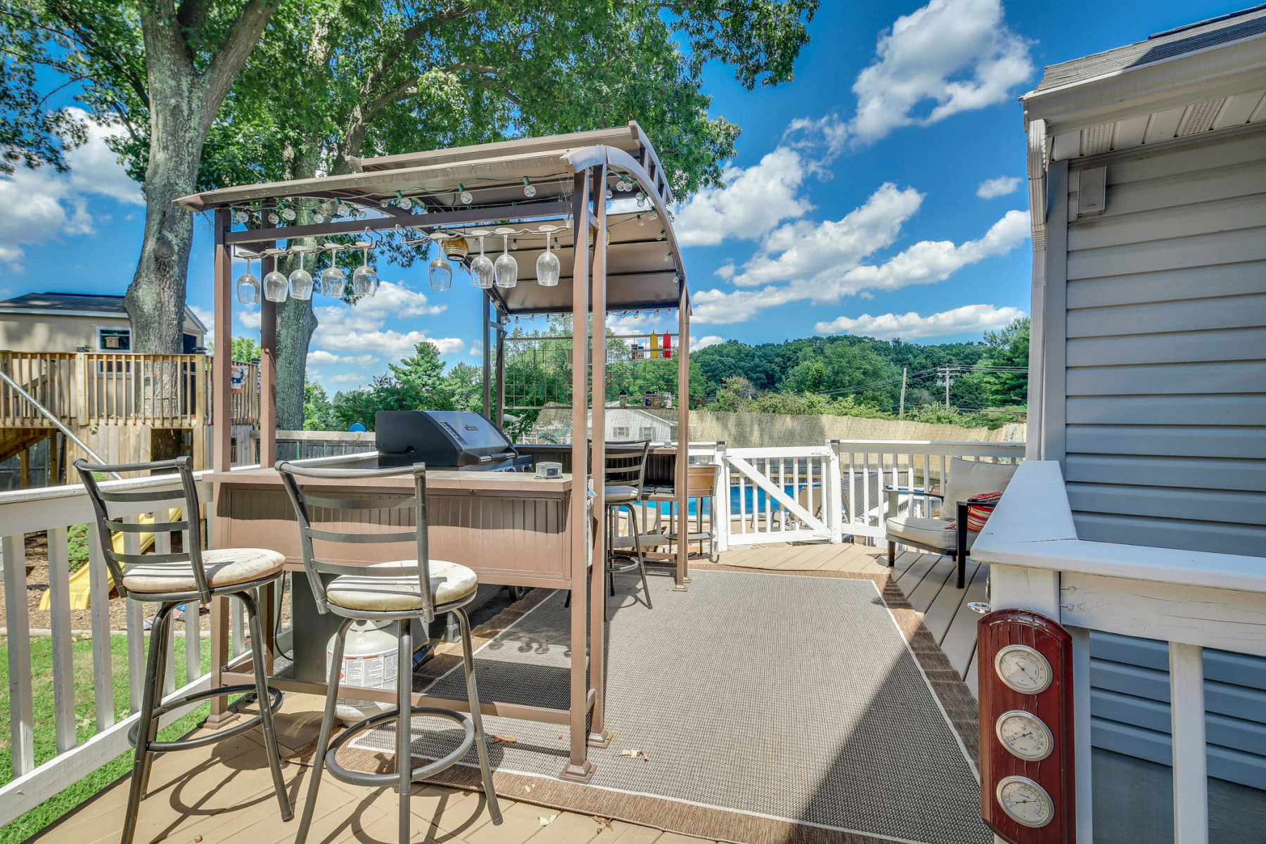 Back deck with pergola bar setup and seating