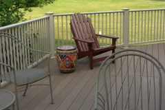 Composite deck with white railings and Adirondack chair lounge area