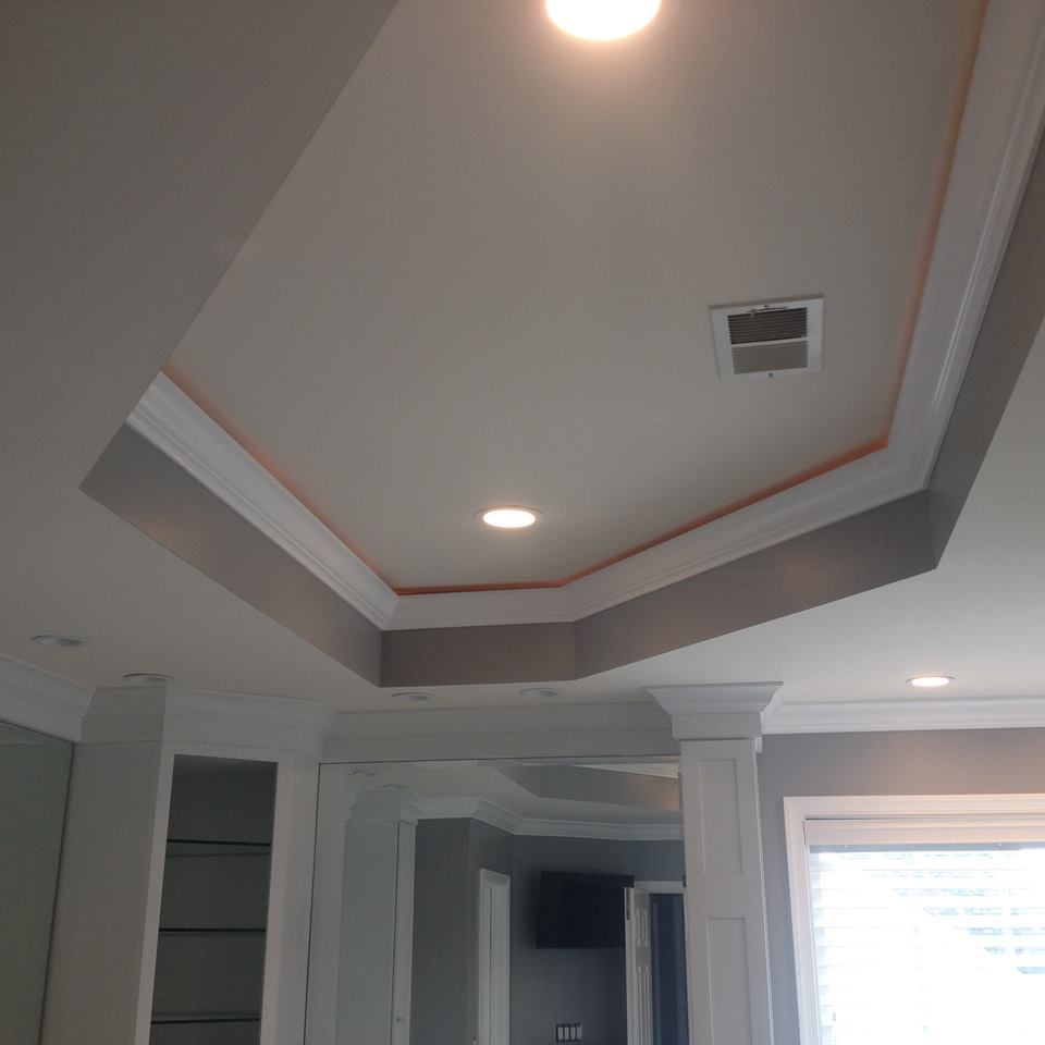 Tray ceiling detail with custom trim, recessed lighting, and accent paint