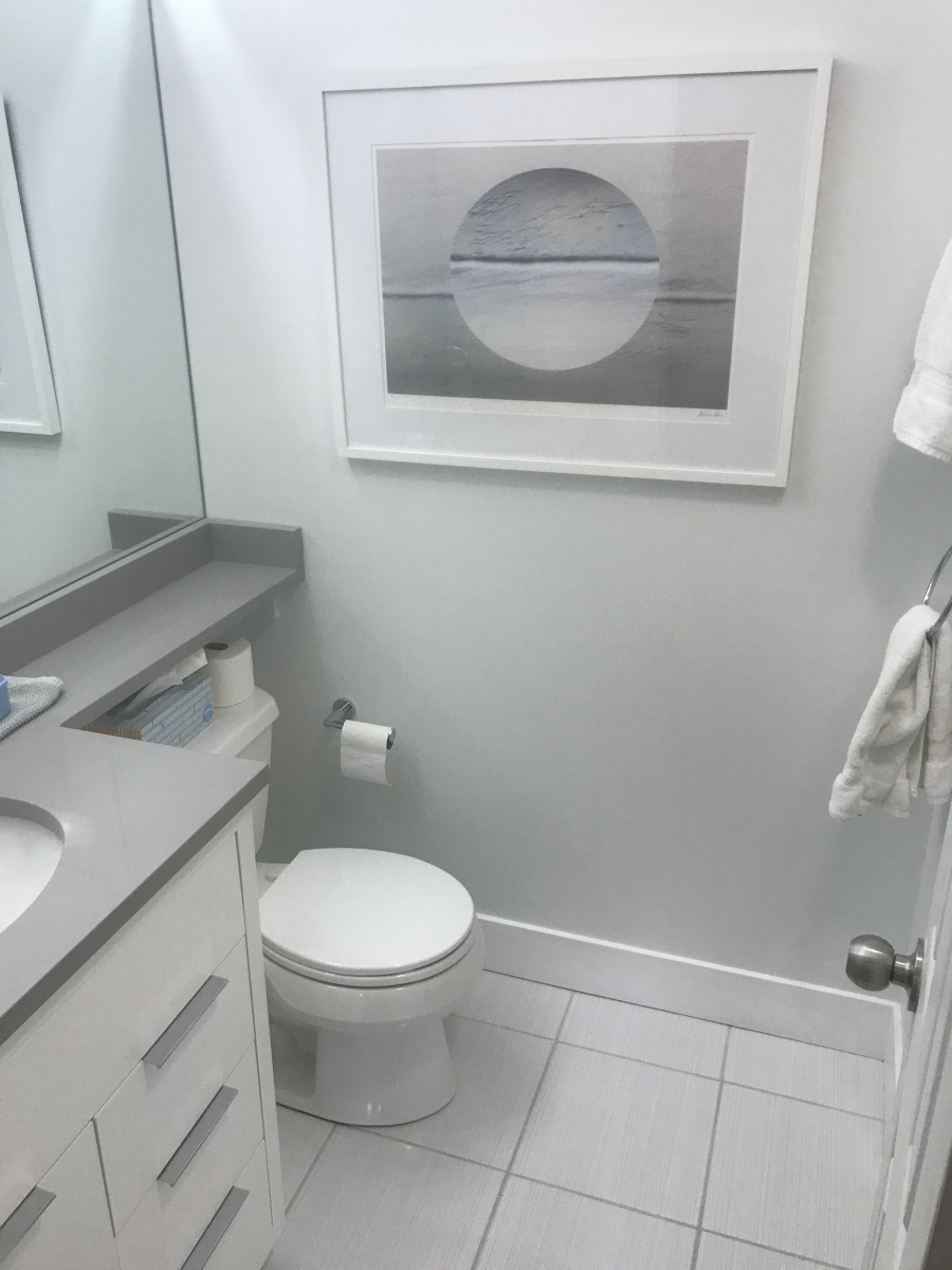 Modern guest bath with white vanity, quartz counter, and tiled floor