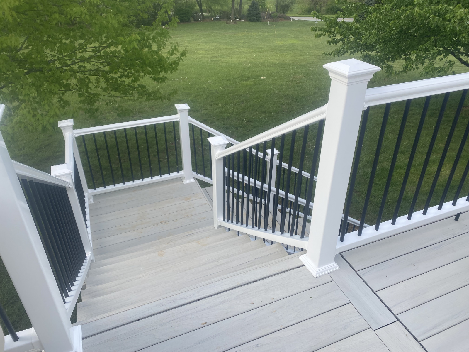 Composite deck stairs with white posts and black balusters