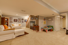 Open finished basement with carpet, play area, and stair access